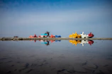 Brightly colored pedal boats lined up ready for a sunny day adventure.