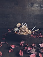 A rustic wooden bowl filled with male face scrub next to fresh eucalyptus leaves.