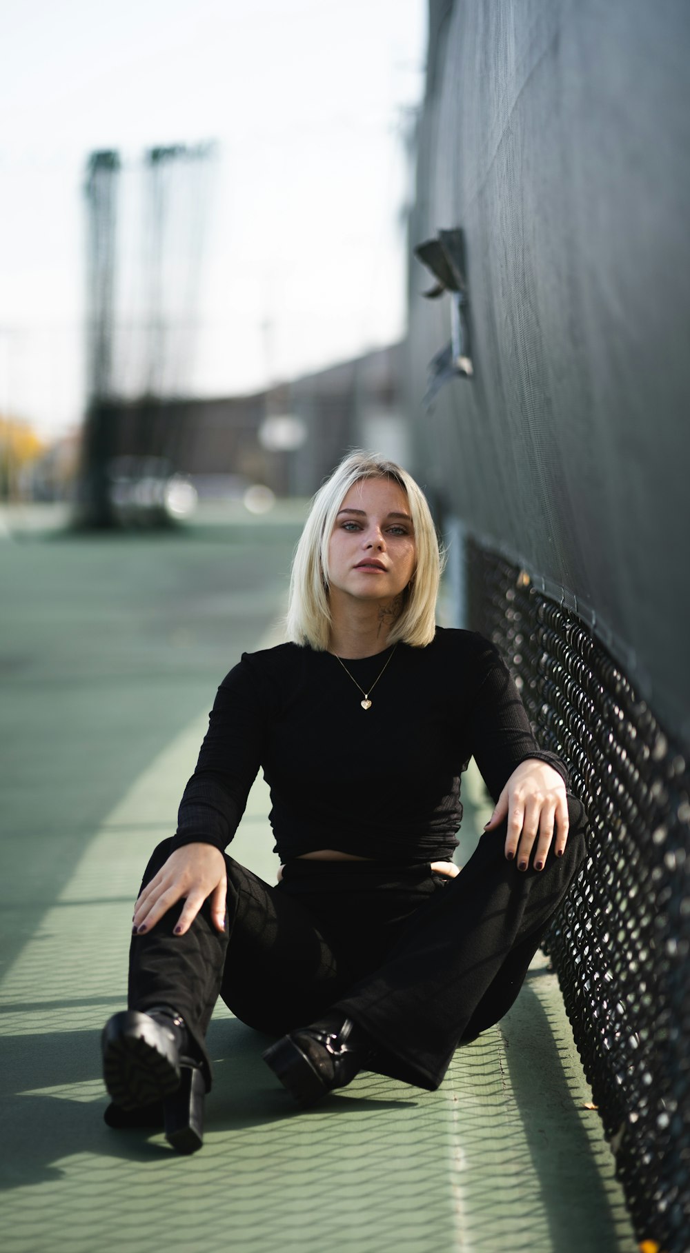 woman in black long sleeve shirt sitting on black metal bench