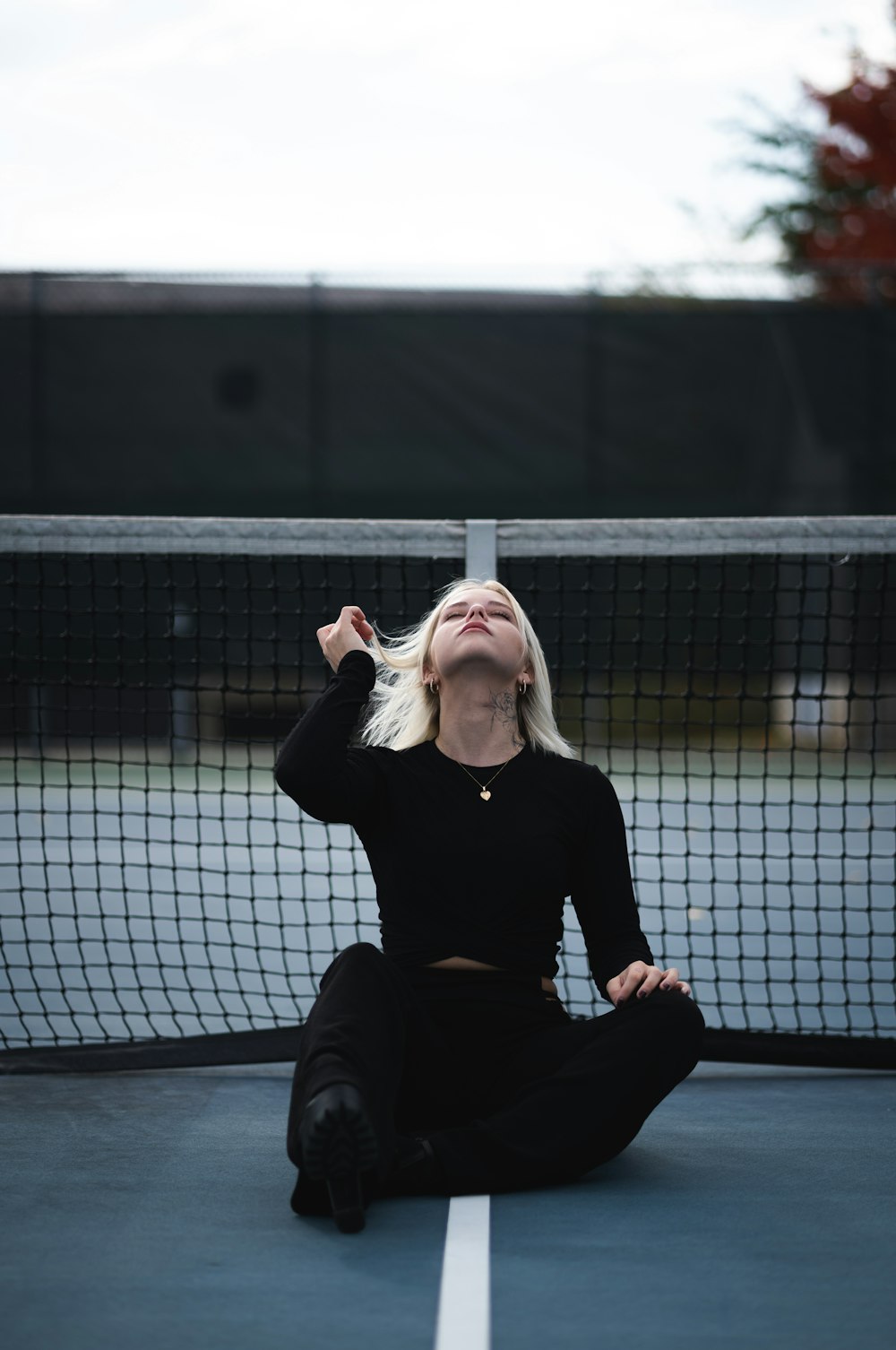 woman in black long sleeve shirt and black pants sitting on black floor