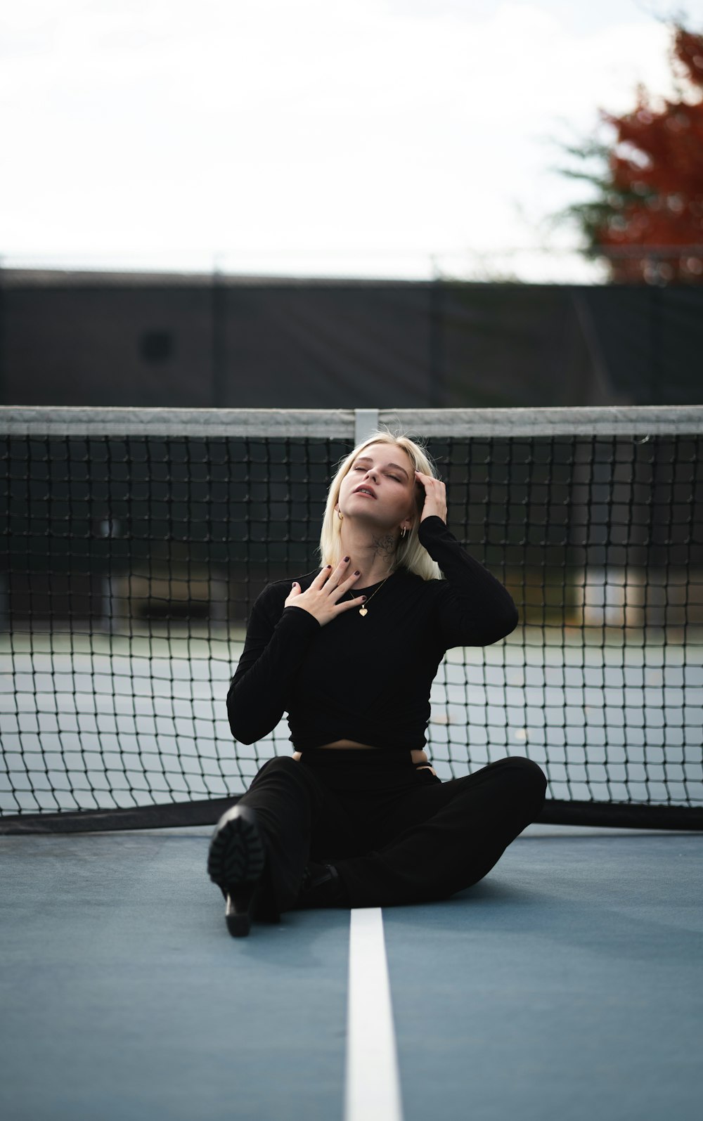 woman in black long sleeve shirt and black pants sitting on floor