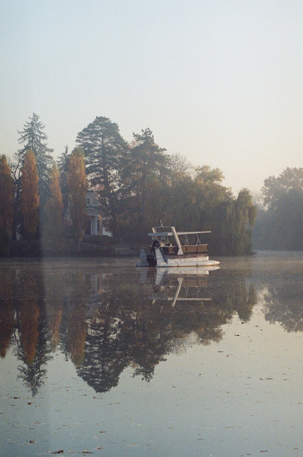 person sitting on bench near lake during daytime