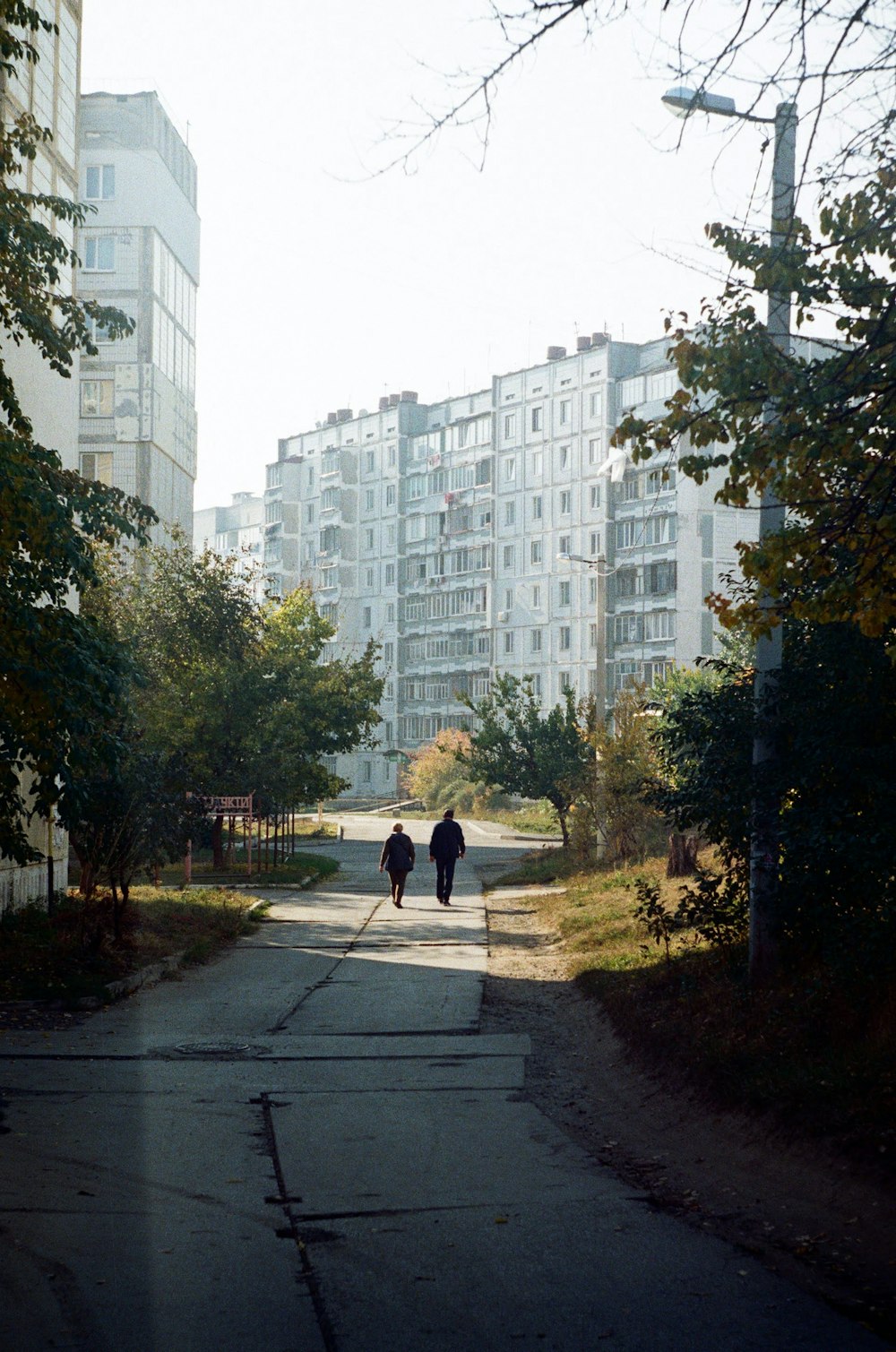 person walking on pathway near high rise building during daytime