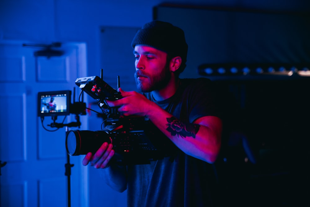 man in black t-shirt holding video camera