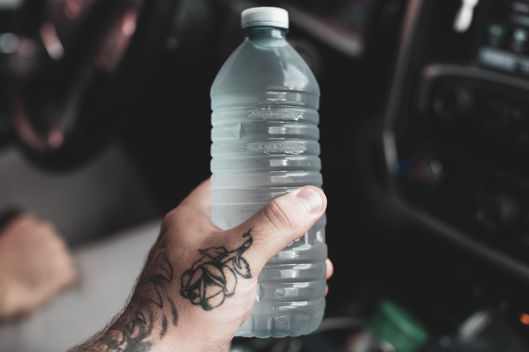 person holding clear plastic bottle,
