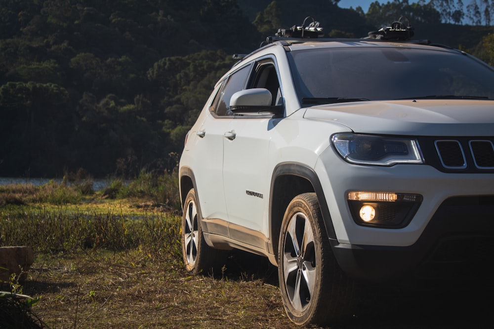 white nissan suv on green grass field during daytime