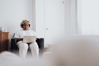 woman in white long sleeve shirt sitting on black sofa chair