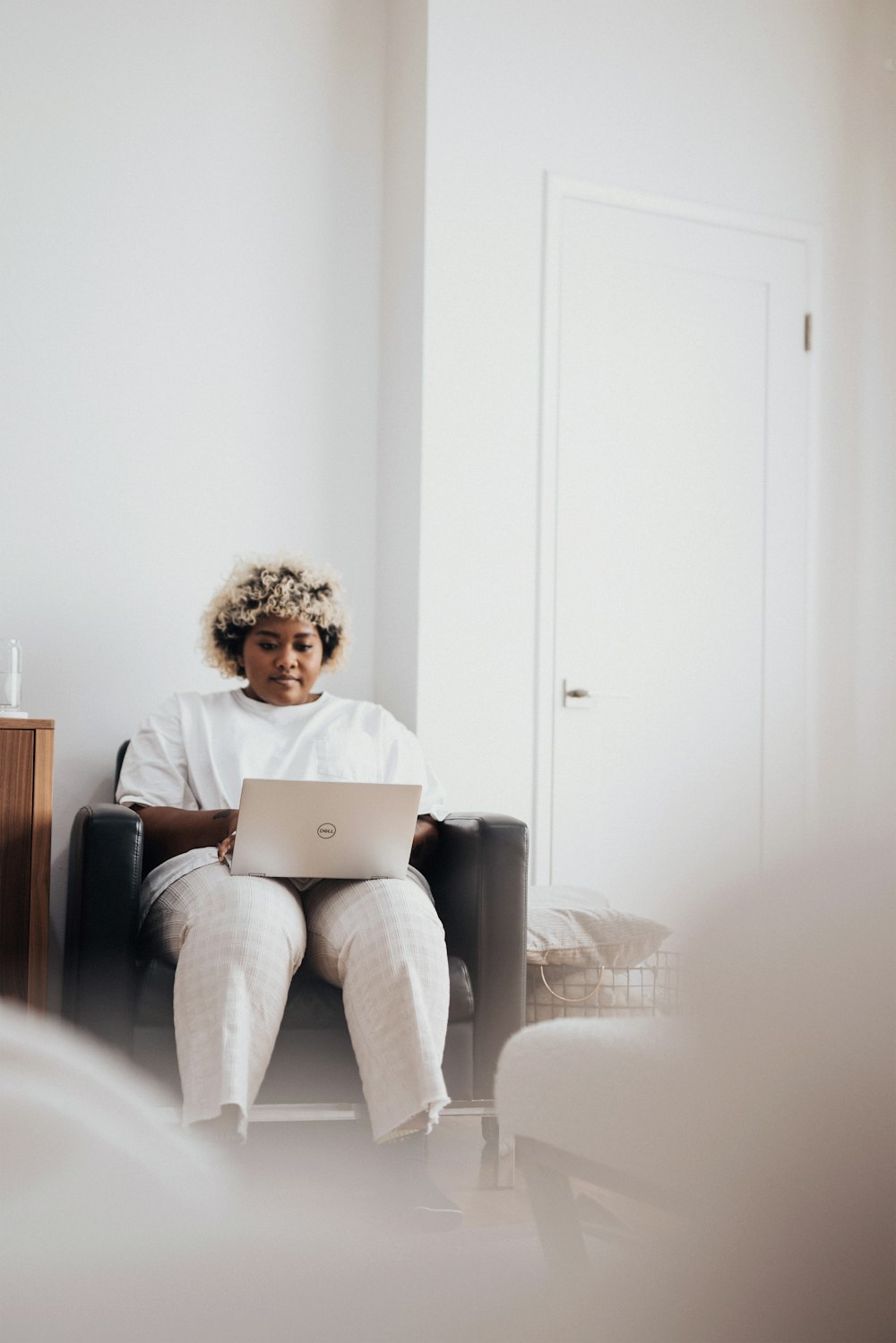 woman in gray pants sitting on gray couch