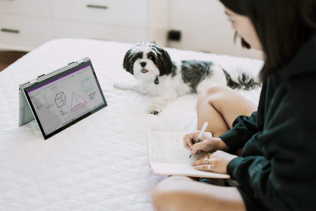 woman in black dress sitting on floor with white and black dog