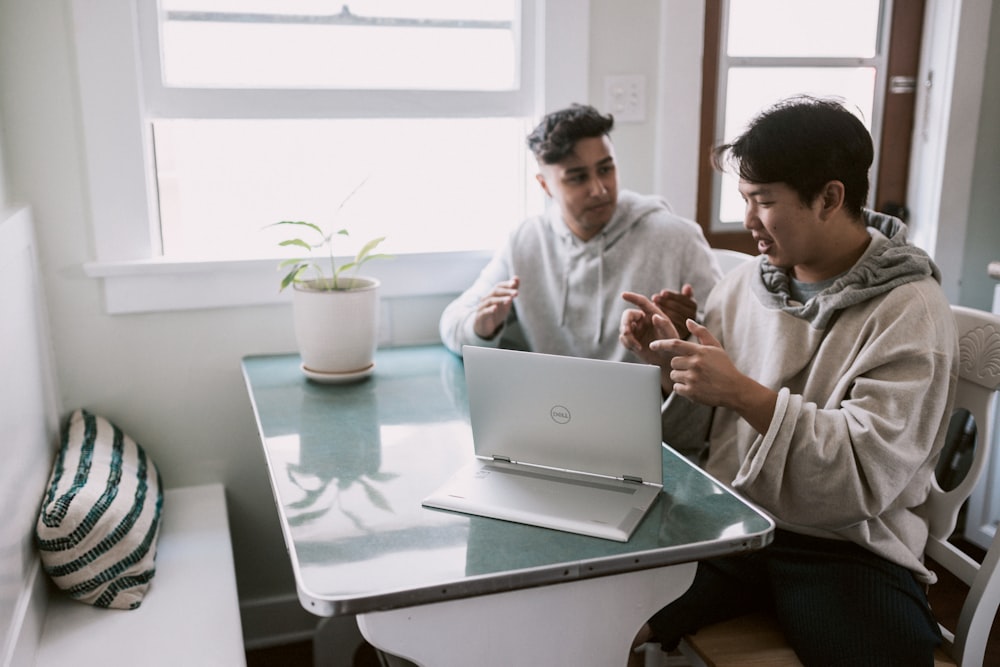 man in white dress shirt using silver laptop