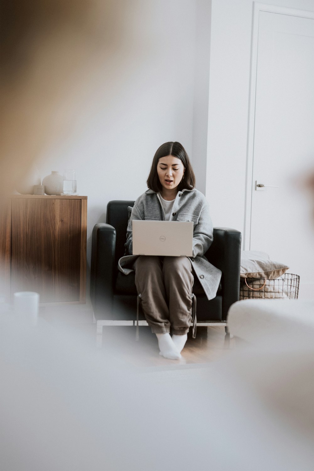 woman in gray long sleeve shirt sitting on gray sofa chair