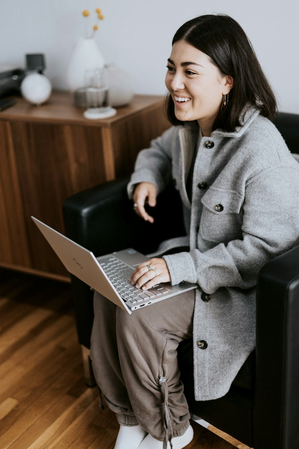 woman in gray coat using laptop