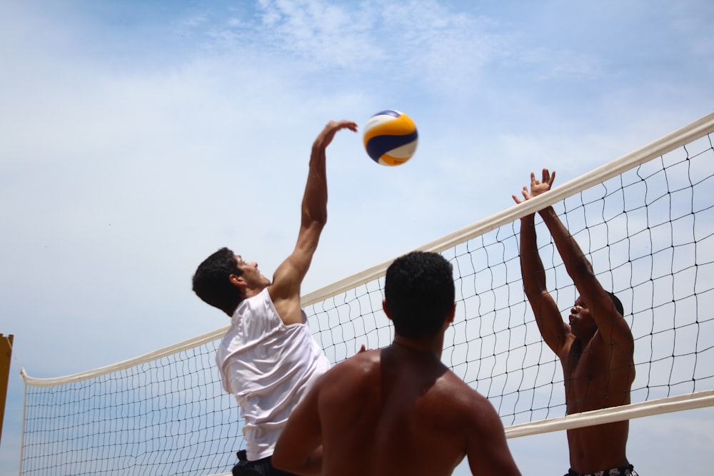 homme en short blanc jouant au volley-ball pendant la journée