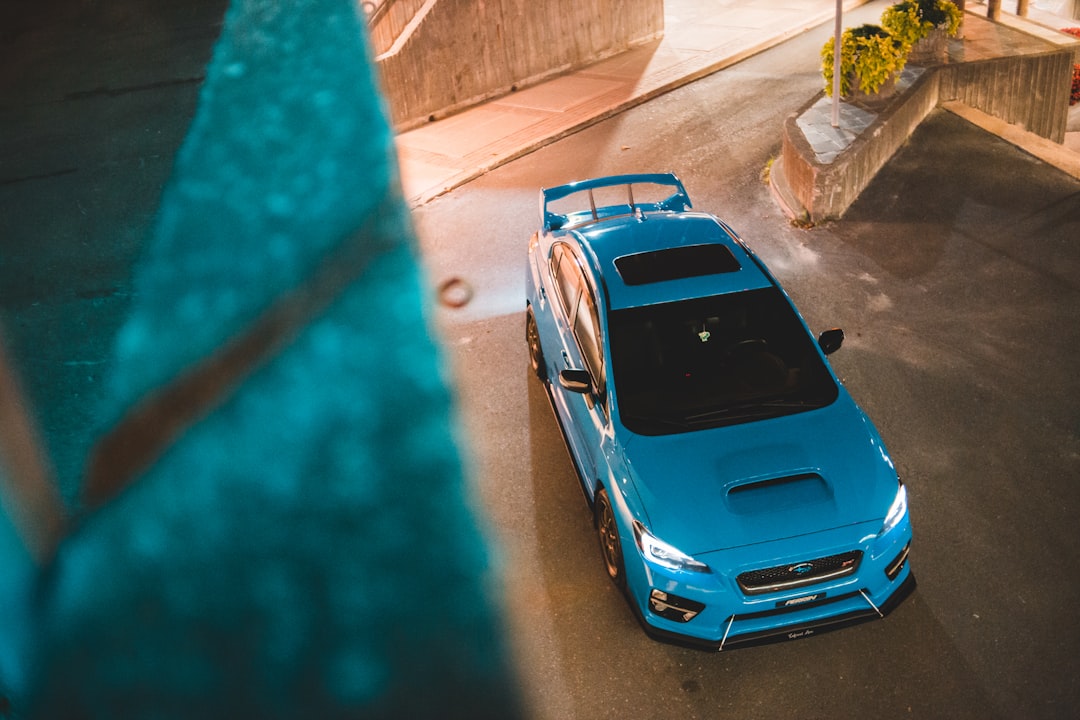 blue car parked on sidewalk during daytime