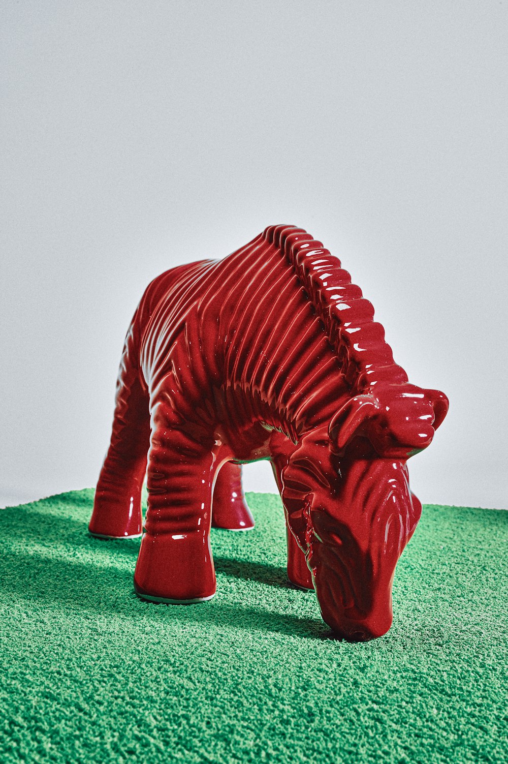 red elephant figurine on green textile