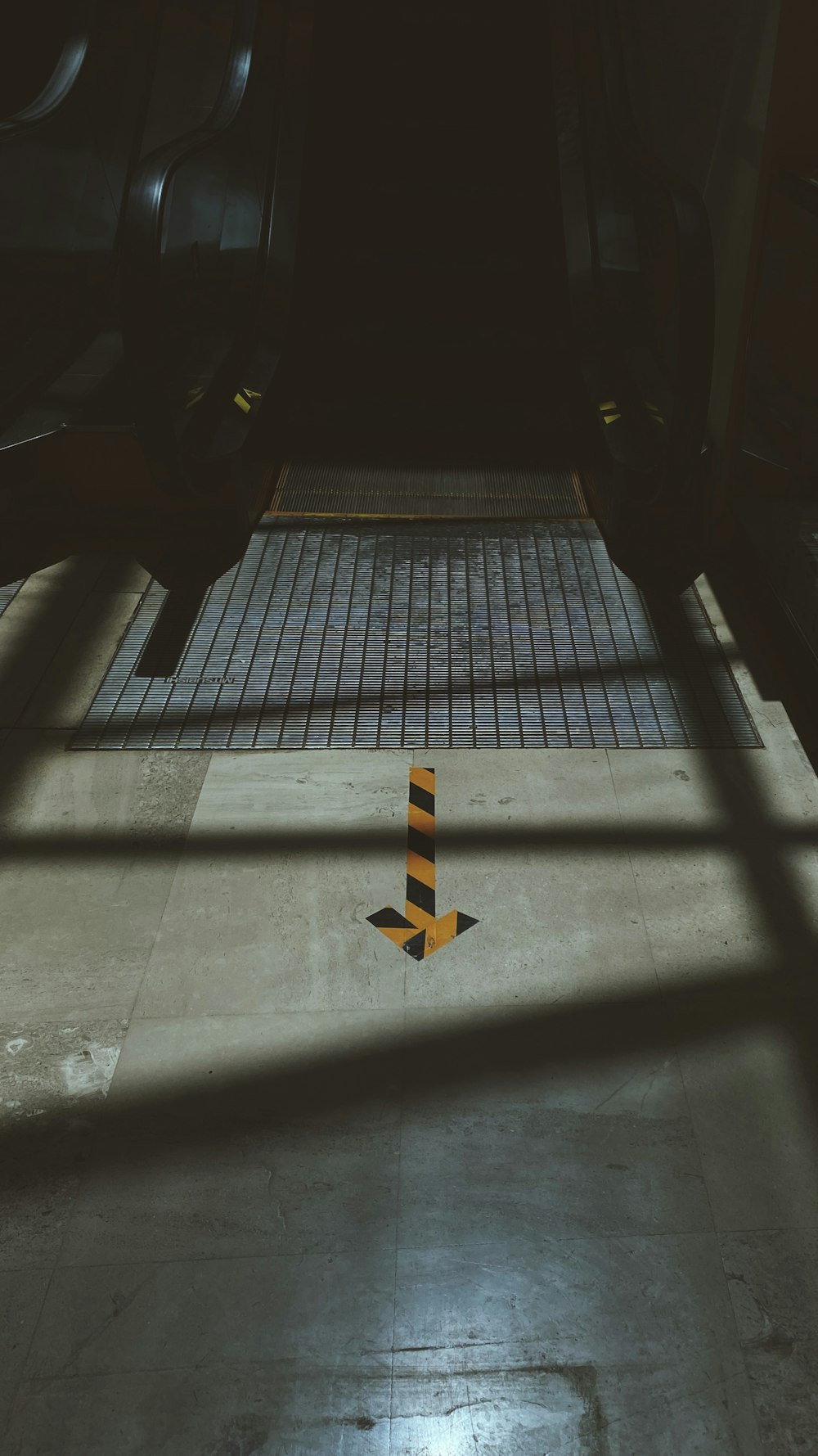 yellow arrow sign on gray concrete floor