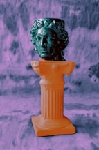 white ceramic figurine on gray concrete stand