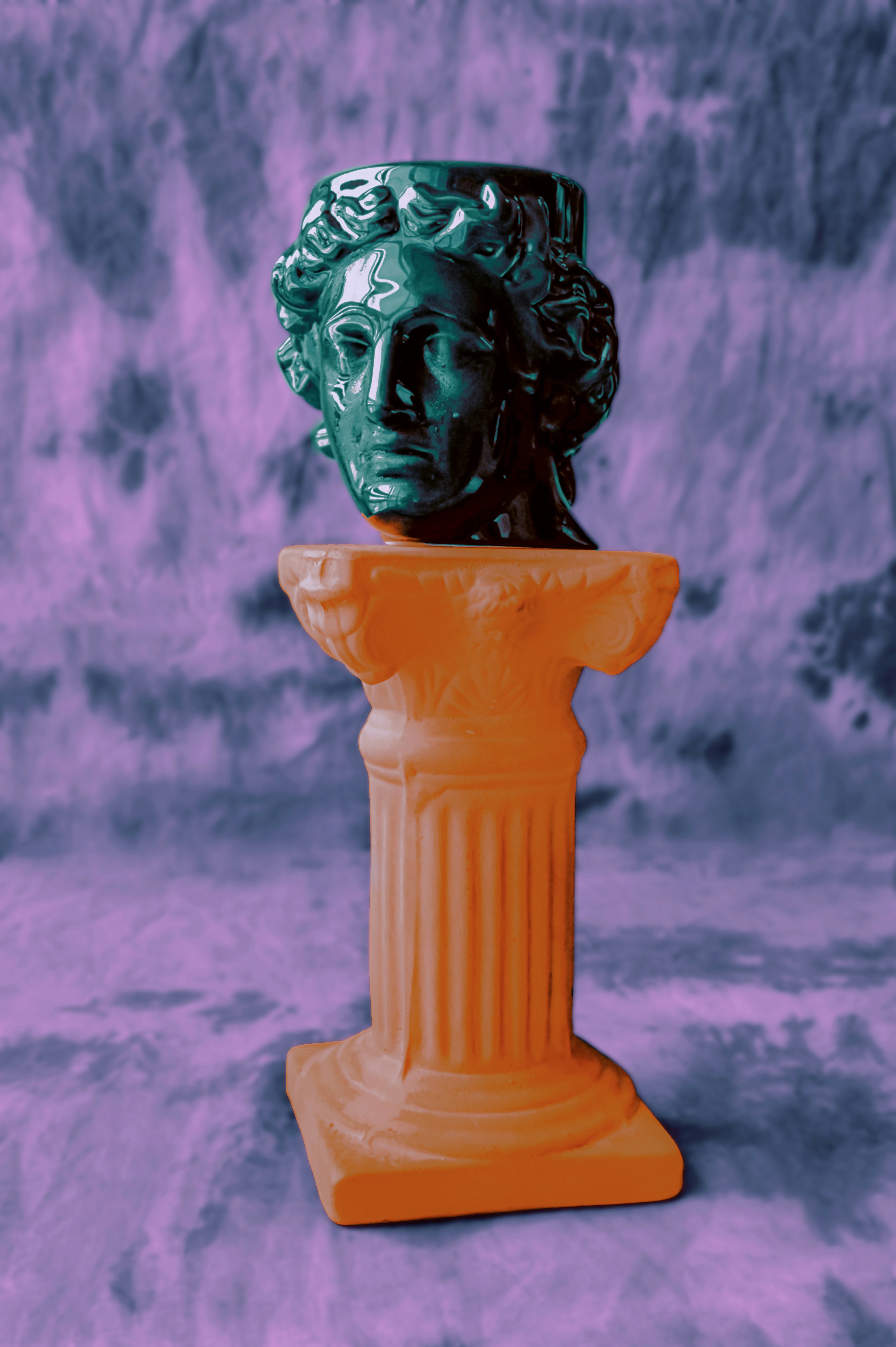 blue head on top of neon orange column with psicodelich purple background