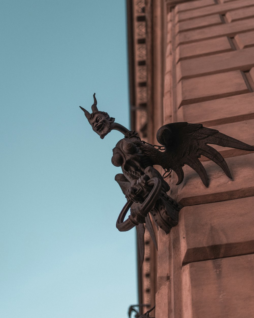 Statua del drago nero sull'edificio in cemento marrone durante il giorno