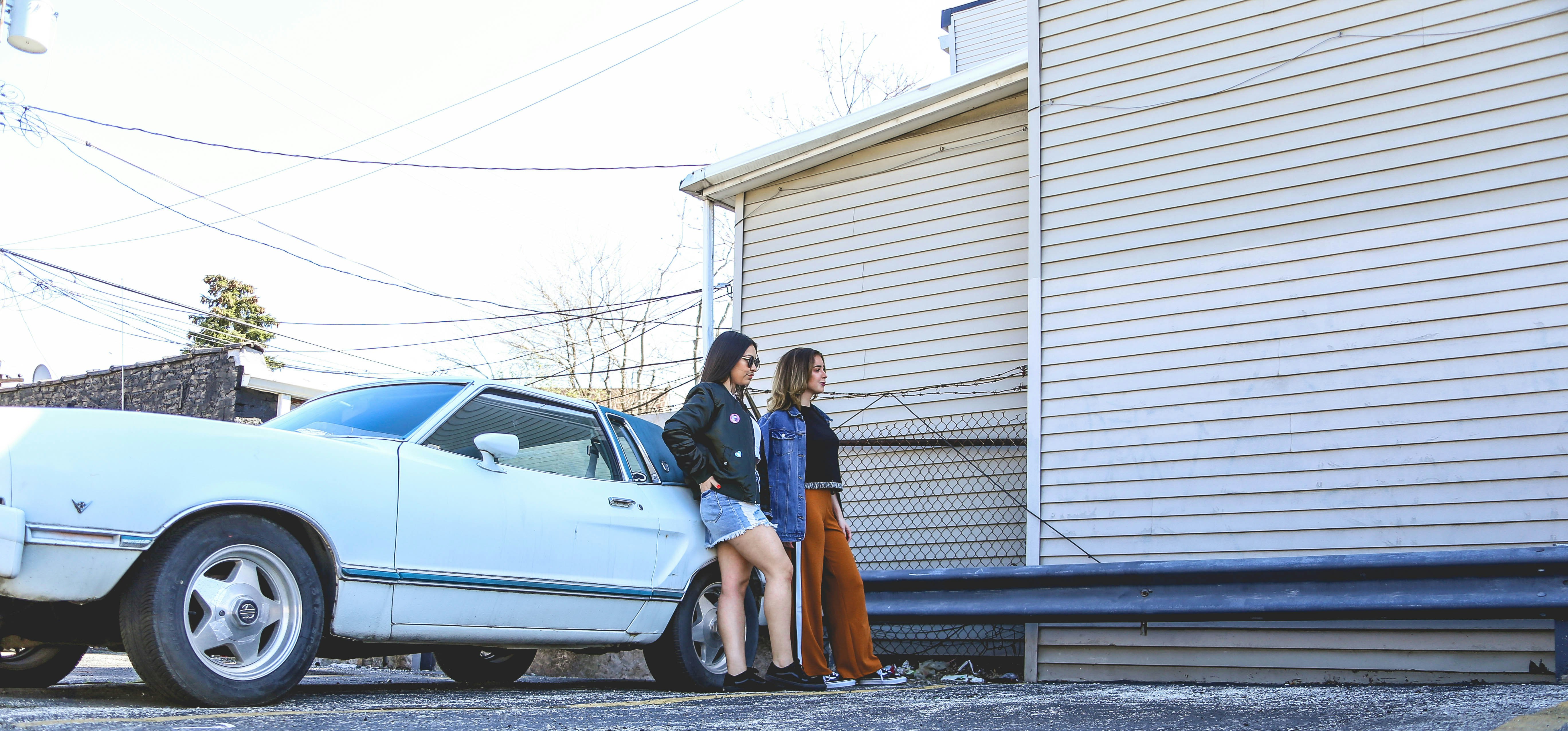 man and woman standing beside white car