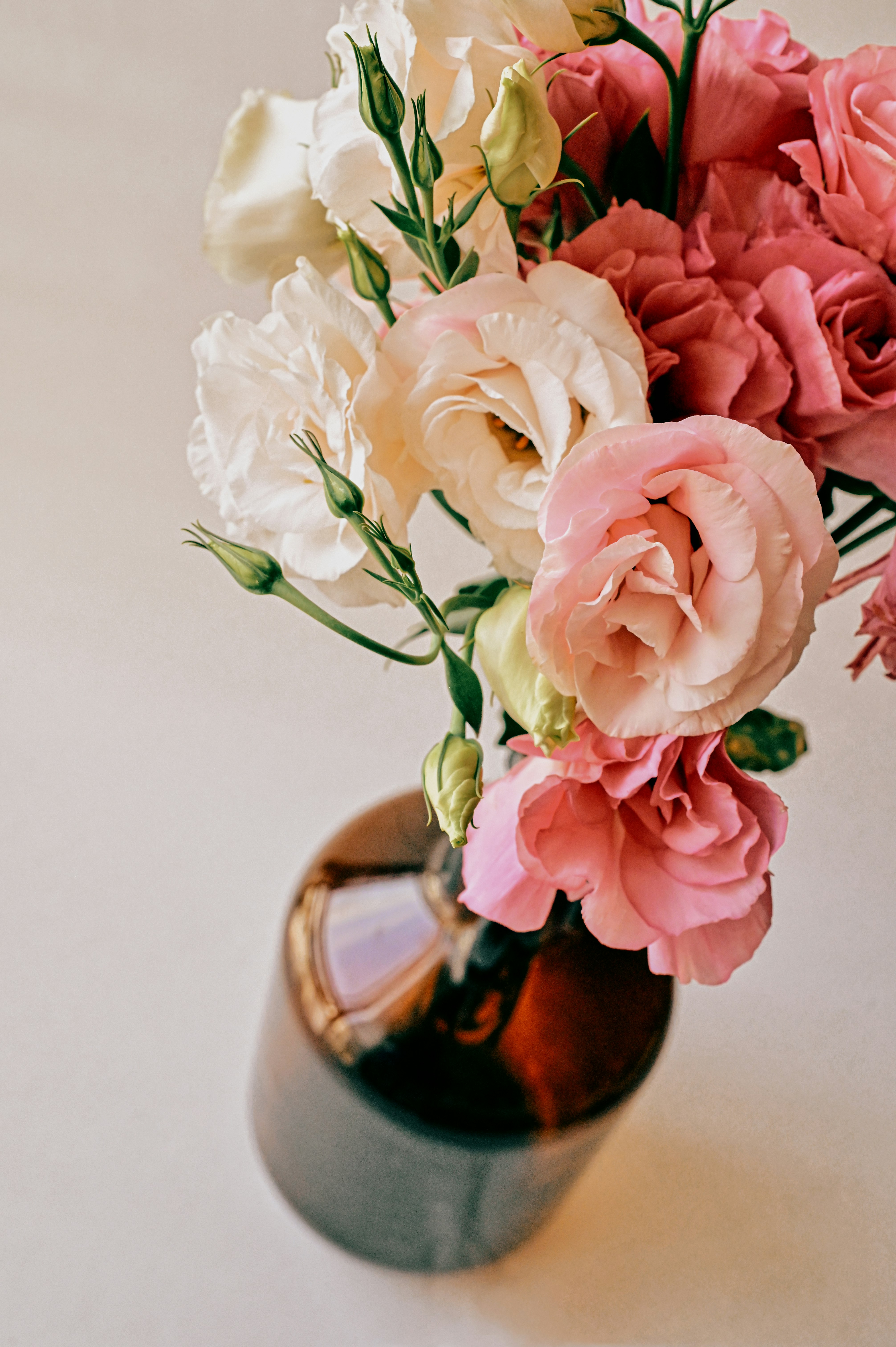 pink and white roses in brown vase