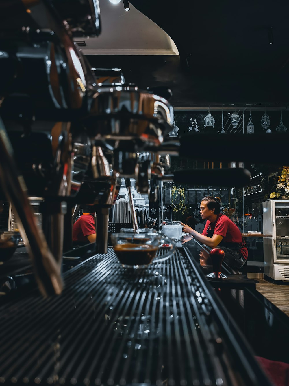 man in red crew neck t-shirt sitting on brown wooden chair