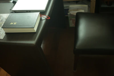 Close-up of legal books and documents with a matte gold pen on a black desk.