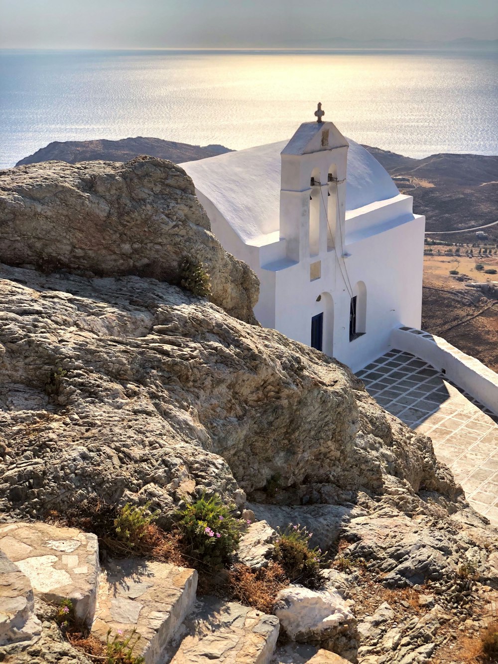 Iglesia blanca en una formación rocosa marrón durante el día