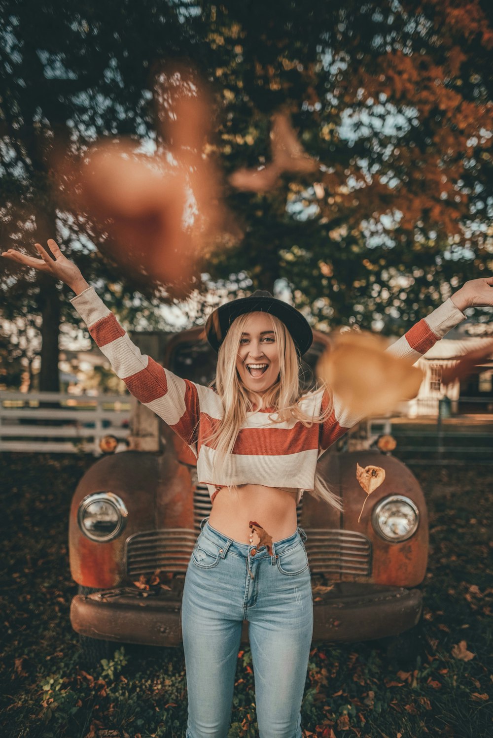 woman in red and white striped long sleeve shirt and blue denim shorts standing and smiling