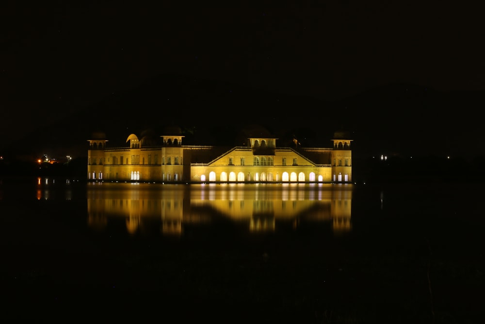 lighted house near body of water during night time