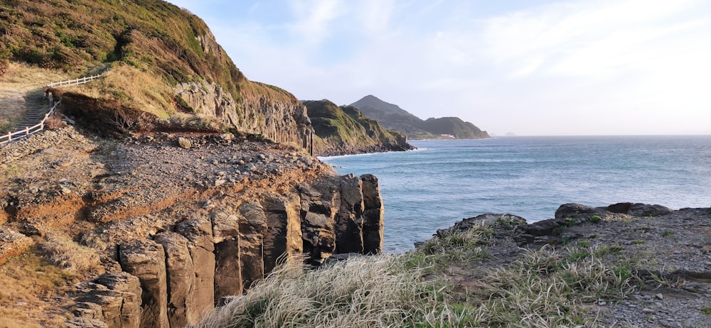 brown rock formation near body of water during daytime