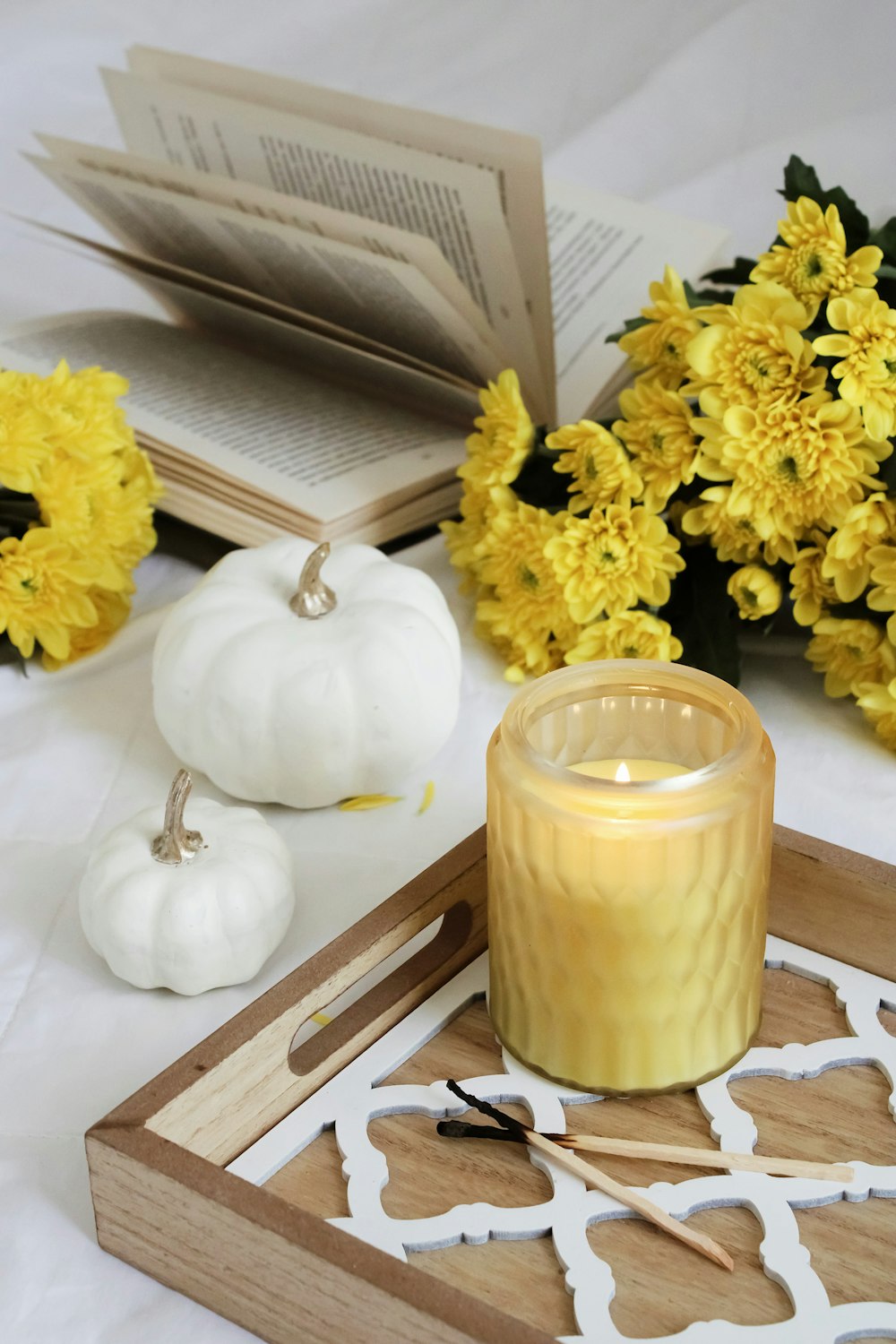 yellow flower beside white candle
