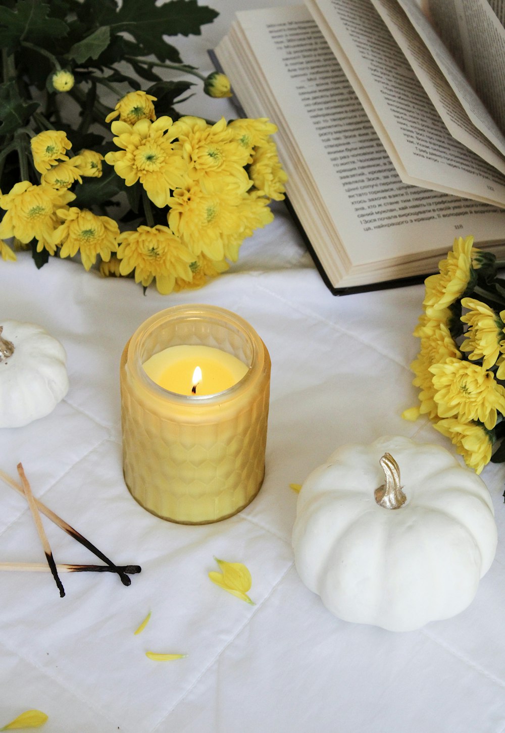 yellow flower beside white candle