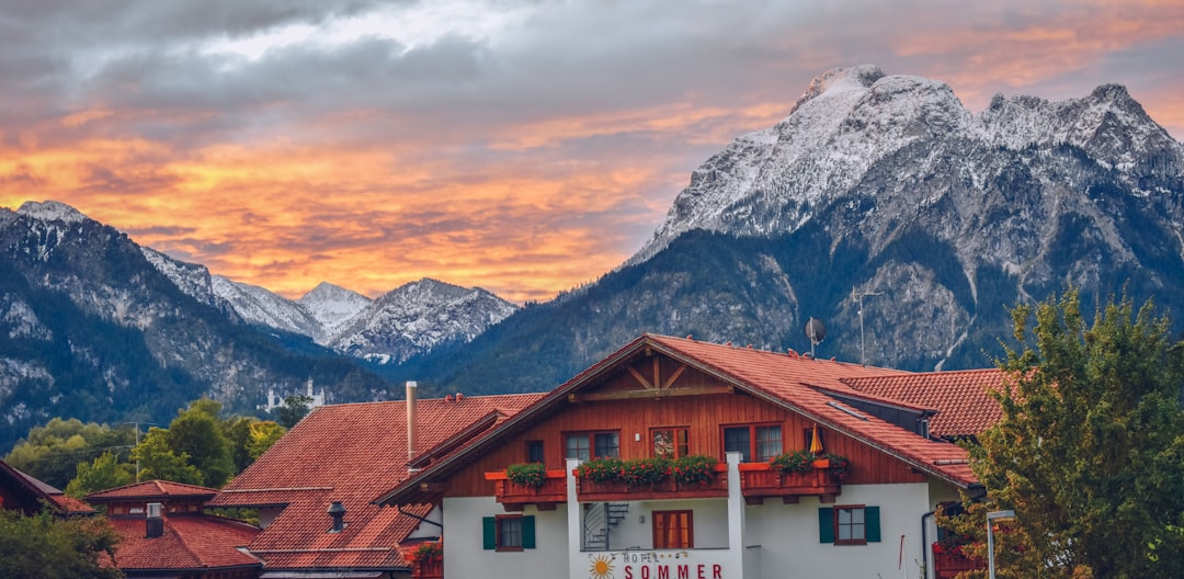 white and brown house near snow covered mountain during daytime