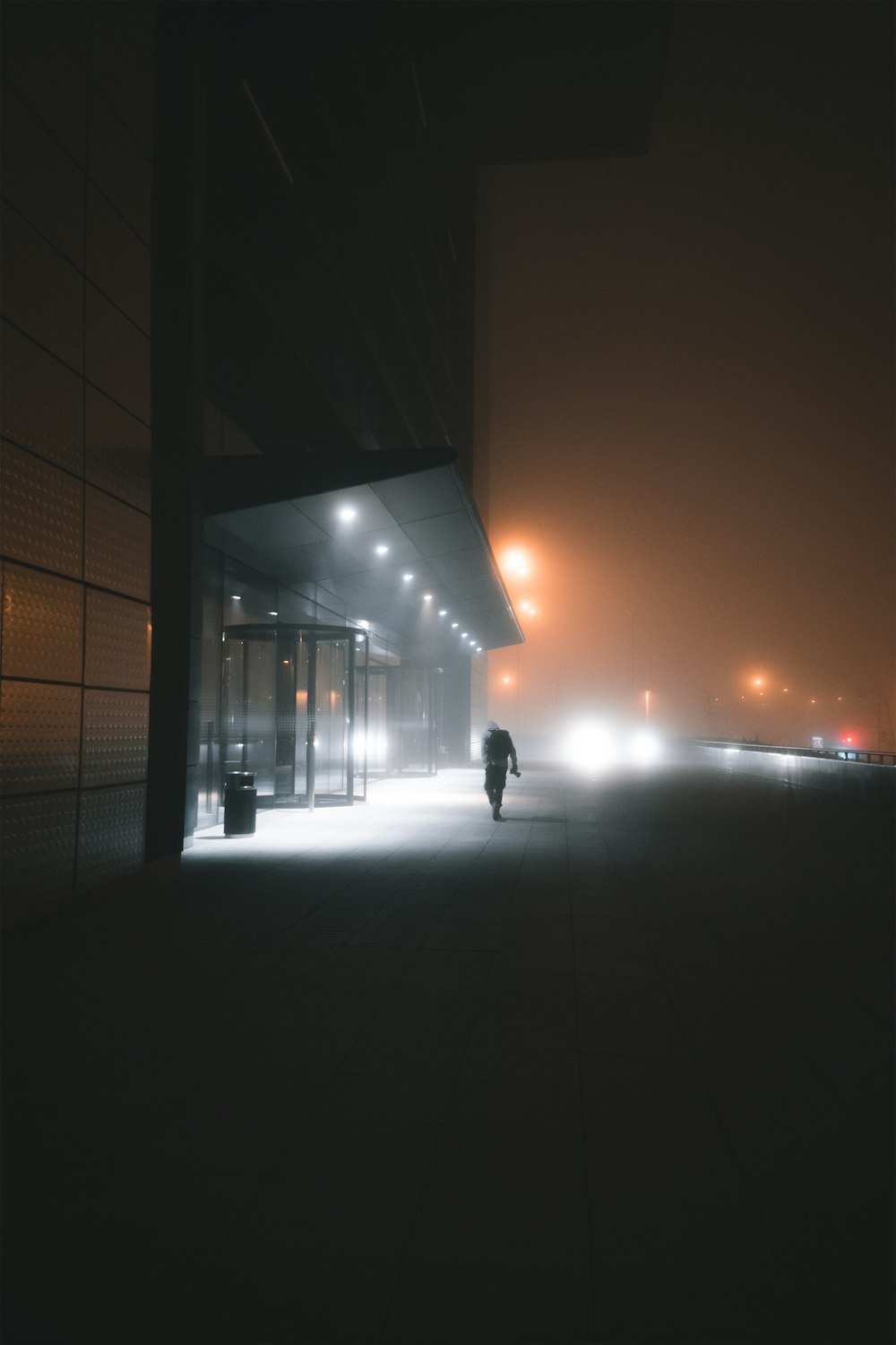 silhouette of person walking on sidewalk during sunset