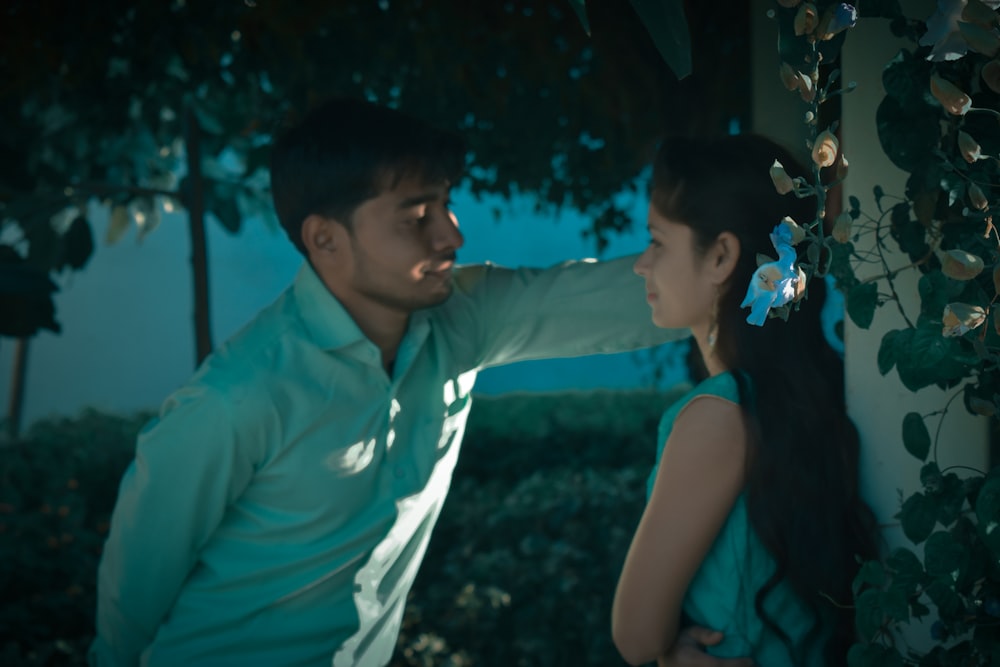 man in white dress shirt kissing woman in black sleeveless dress