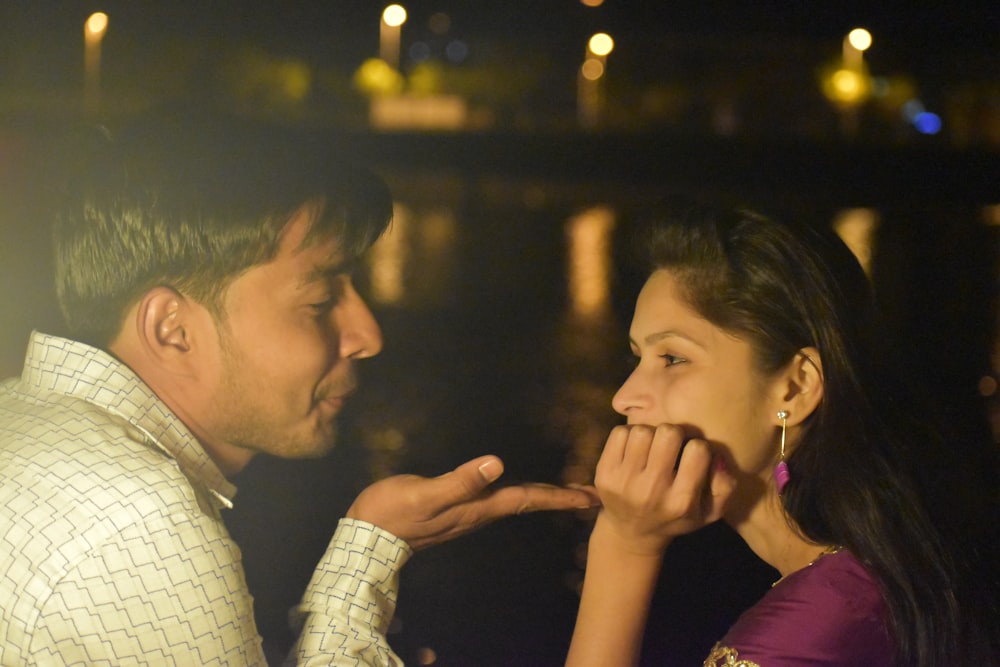 man in white and black checkered dress shirt kissing womans cheek