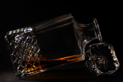 Close-up of an elegant decanter with intricate golden patterns reflecting soft light.