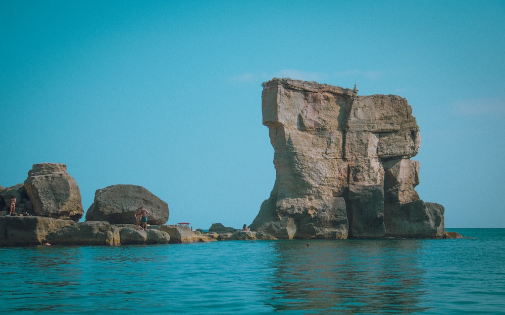 brown rock formation on blue sea under blue sky during daytime