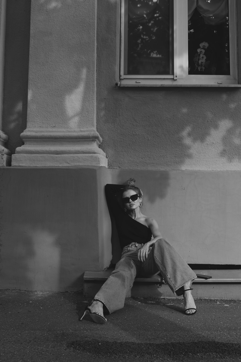 woman in black sunglasses sitting on concrete stairs