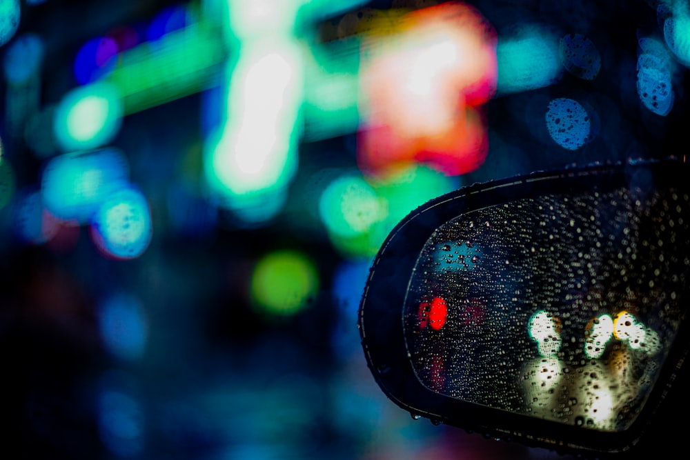 black car side mirror with water droplets