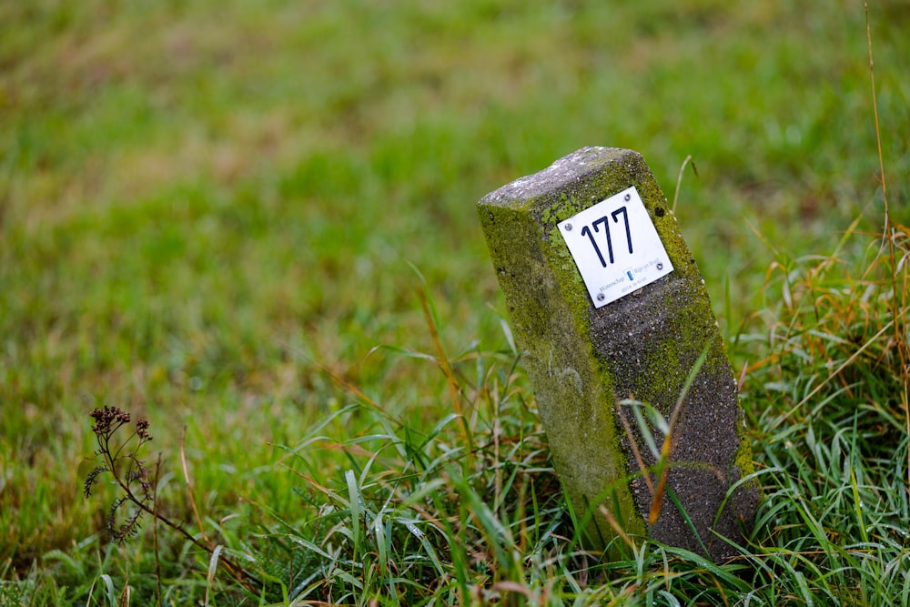 gray concrete cross on green grass during daytime