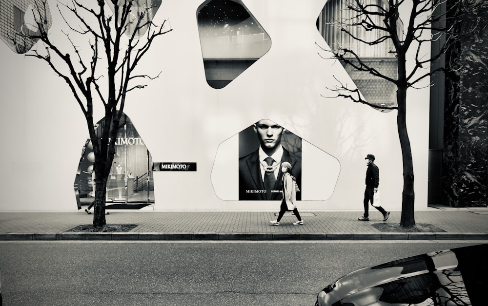 woman in black coat walking on sidewalk during daytime