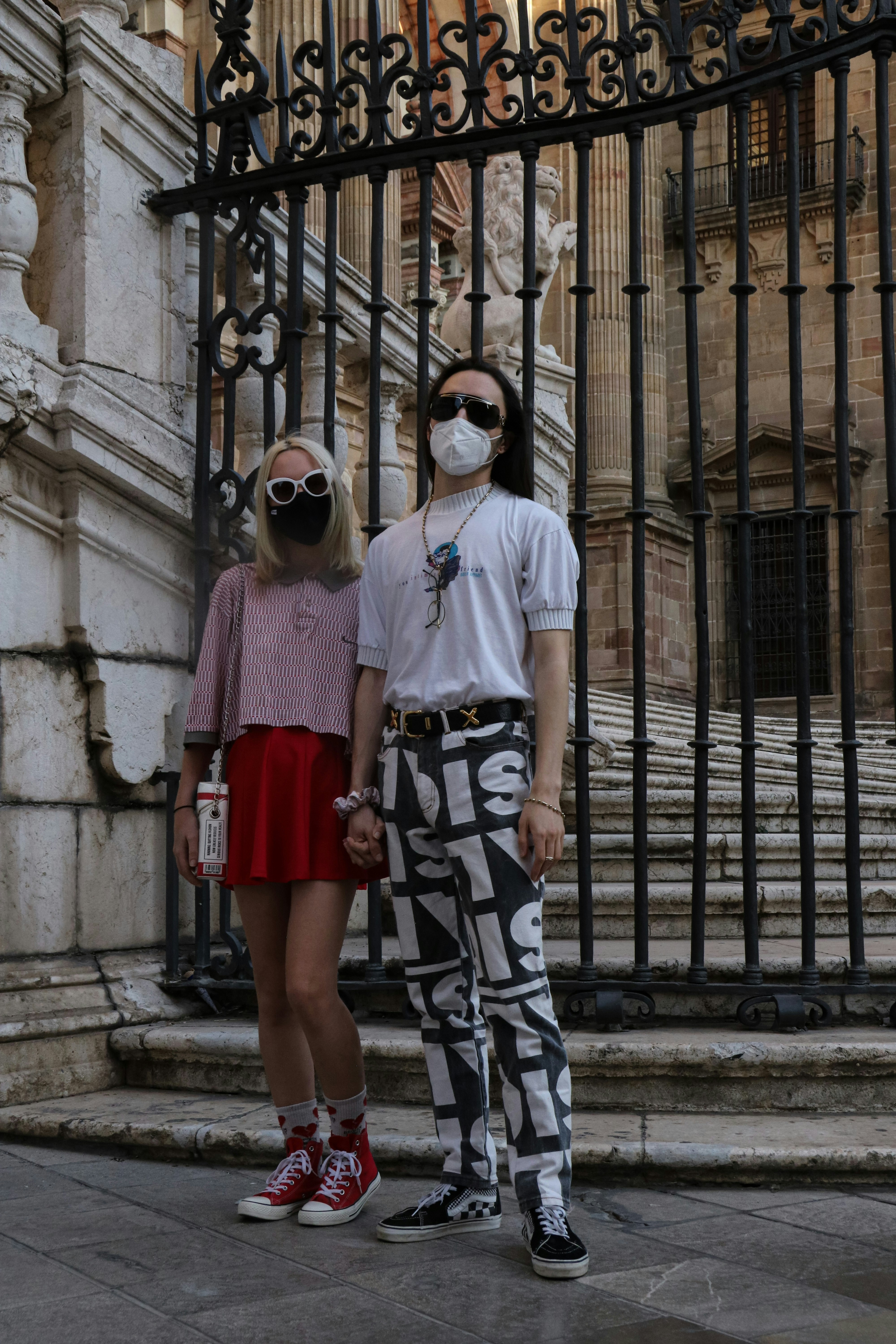 woman in white t-shirt and black and white skirt standing beside woman in red skirt