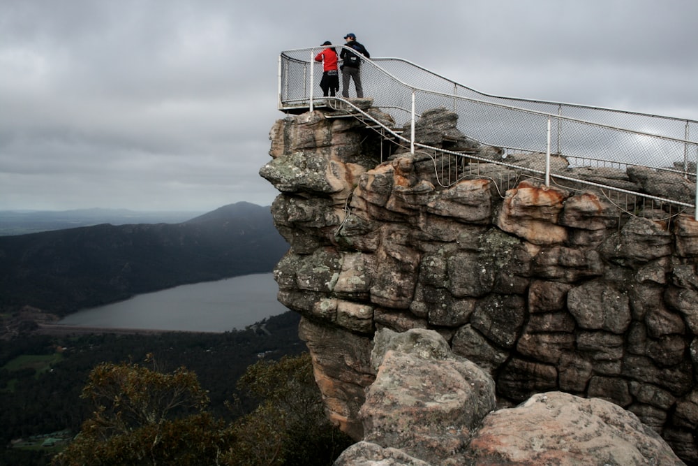 person in black jacket sitting on rock formation during daytime