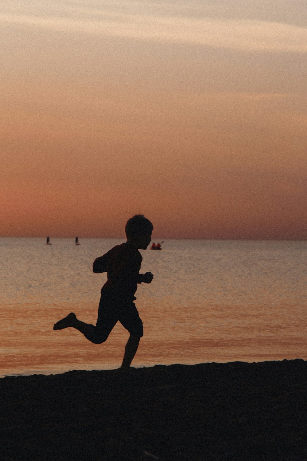 a person running on a beach at sunset