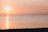 A serene sunset over the bay with a group practicing sup yoga on calm water.