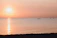 A serene sunset over the bay with a group practicing sup yoga on calm water.