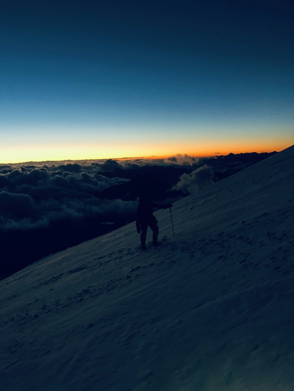 silhouette of man standing on snow covered ground during daytime