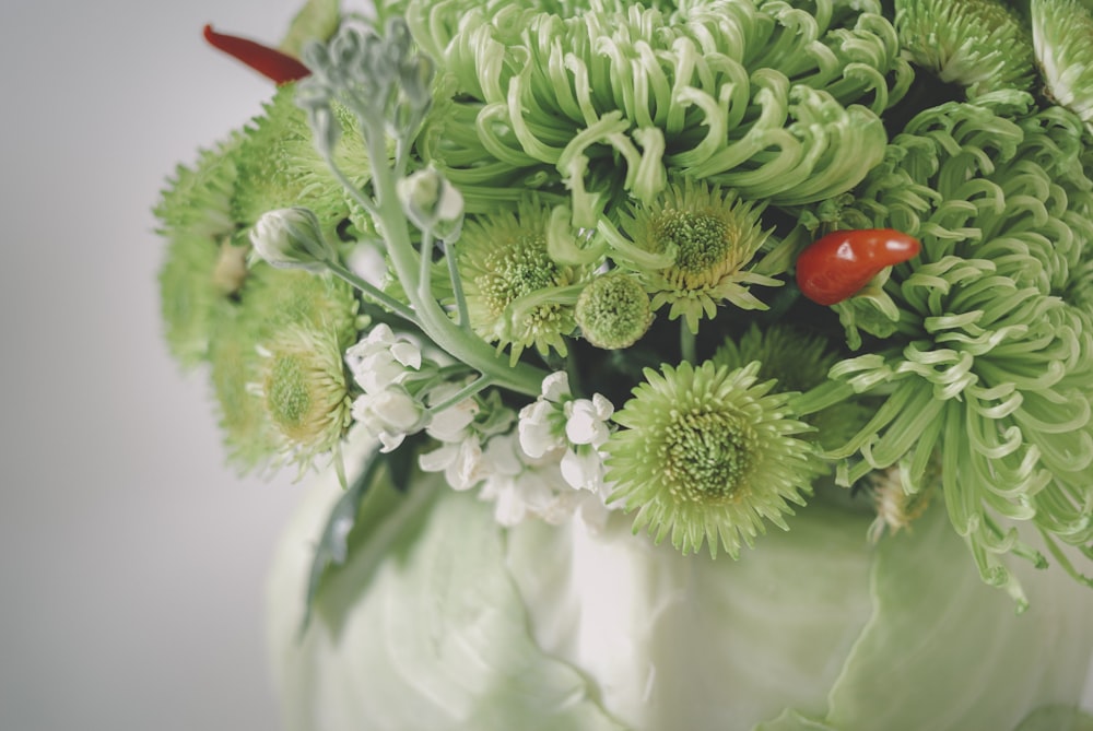 a vase filled with lots of green flowers